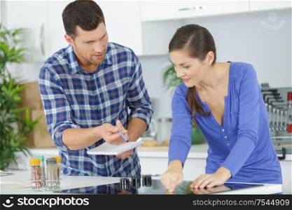 woman and man fixing kitchen sink