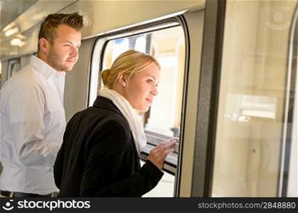 Woman and man looking out train window smiling commuters journey