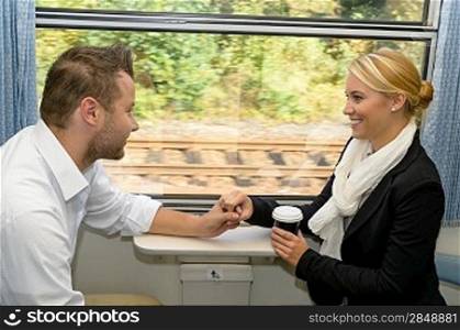 Woman and man on train holding hands sympathy friends commuters