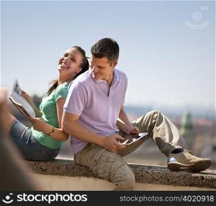 Woman and man sitting on wall