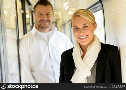 Woman and man smiling standing in train travel commuting colleagues