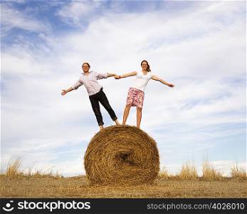 woman and man standing on hay bale