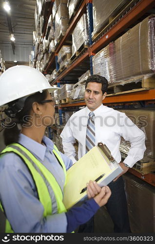 Woman and man talking in distribution warehouse
