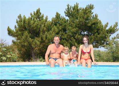 Woman and man with children at the pool board