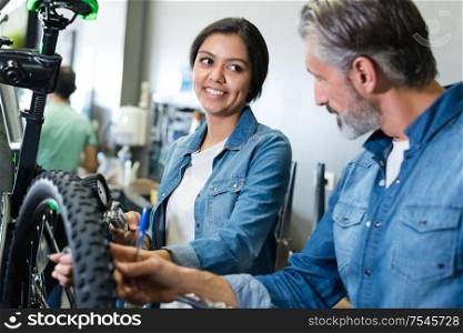 woman and man working with bike