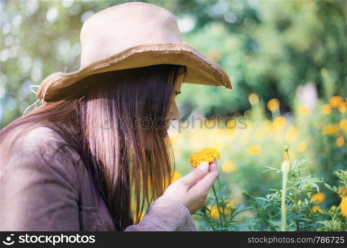 Woman and marigold flower in garden with the sunlight.