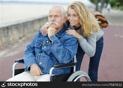 woman and senior man in wheelchair