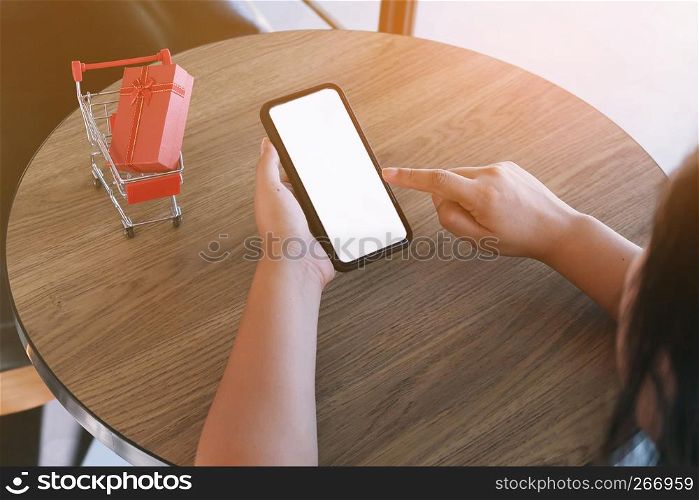 Woman and Small shopping cart with smartphone for Internet online shopping concept