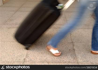 Woman and suitcase. Note that the picture is in motion blur.