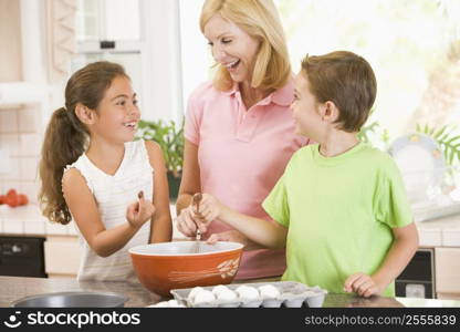 Woman and two children in kitchen baking and smiling