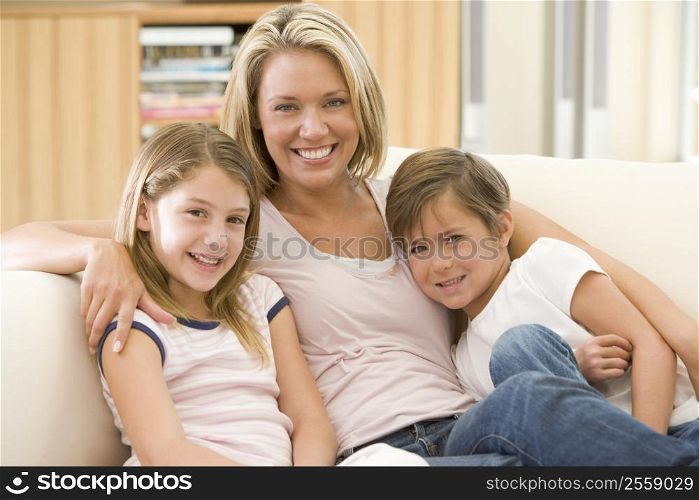 Woman and two young children in living room smiling