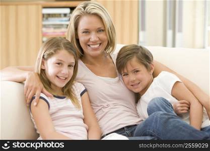 Woman and two young children in living room smiling