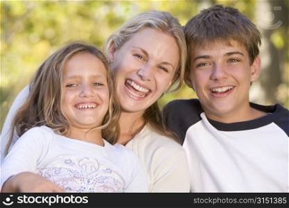 Woman and two young children outdoors laughing