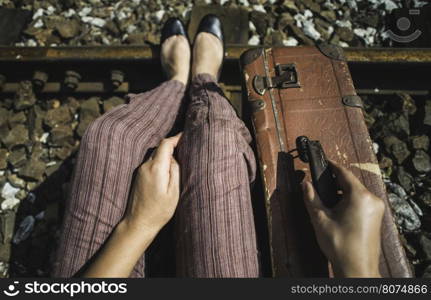 Woman and vintage suitcase on railway road and tunnel.