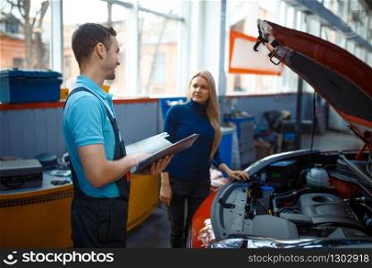 Woman and worker with checklist, car service. Female client on auto station. Automobile checking and inspection, professional diagnostics and repair. Driver and worker with checklist, car service