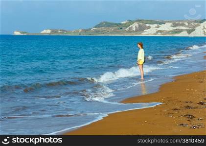 Woman and Xi Beach with red sand. Morning view (Greece, Kefalonia). Ionian Sea.
