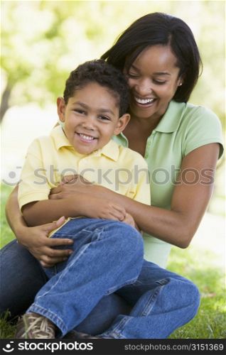 Woman and young boy outdoors embracing and smiling