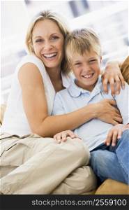 Woman and young boy sitting in living room smiling