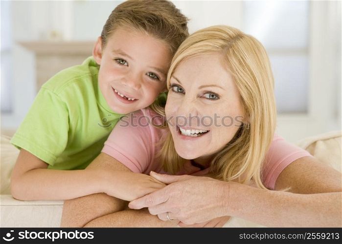 Woman and young boy sitting in living room smiling