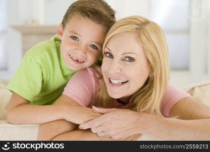 Woman and young boy sitting in living room smiling