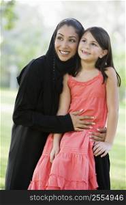 Woman and young girl outdoors in a park smiling (selective focus)