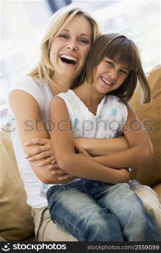 Woman and young girl sitting in living room smiling