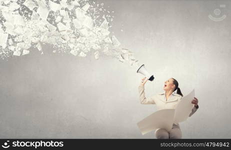 Woman announcing news. Portrait of young businesswoman with newspaper screaming in megaphone