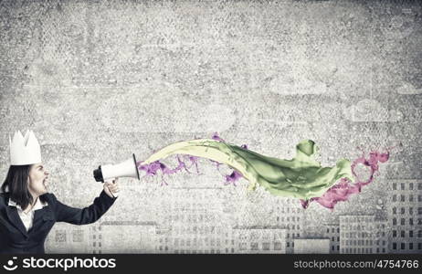 Woman announcing something. Young businesswoman in paper crown screaming in megaphone