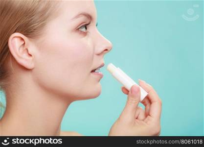 woman applying balsam for lips. Female putting applying lip balm moisturizing balsam. Girl taking care of lips. Skincare.