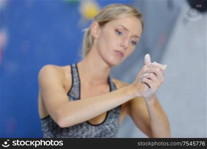 woman applying chalk on her hands before climbing