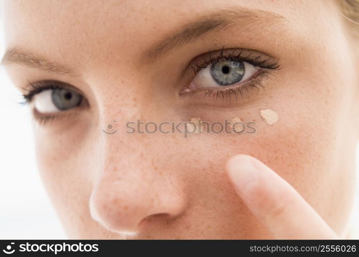 Woman applying concealer