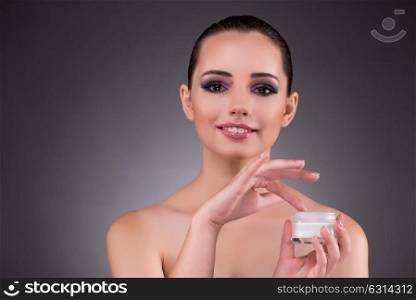 Woman applying cream in beauty concept