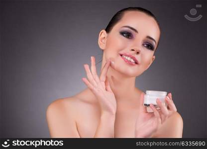 Woman applying cream in beauty concept