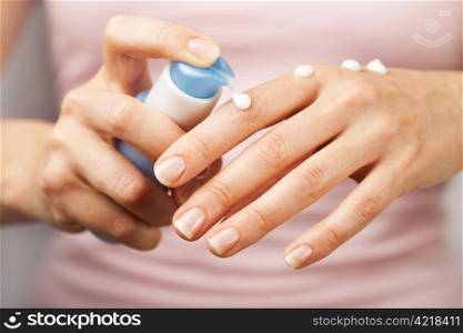 woman applying cream on hands