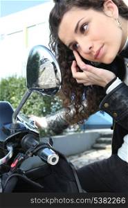 Woman applying eye make-up with the help of her motorcycle&rsquo;s mirror