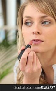 Woman applying lip gloss