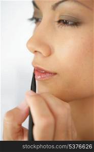 Woman applying lip make-up with pencil