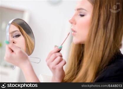 Woman applying lipstick with brush