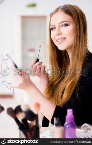 Woman applying lipstick with brush