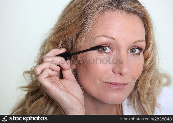 Woman applying mascara