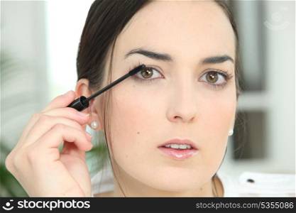 Woman applying mascara