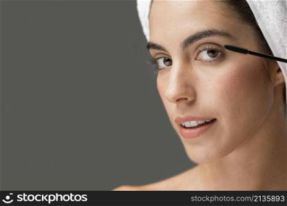 woman applying mascara her lashes