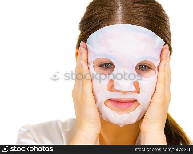Woman applying sheet mask on her face, on white. Girl taking care of skin complexion. Beauty treatment. Skincare.. Woman applying sheet mask on face