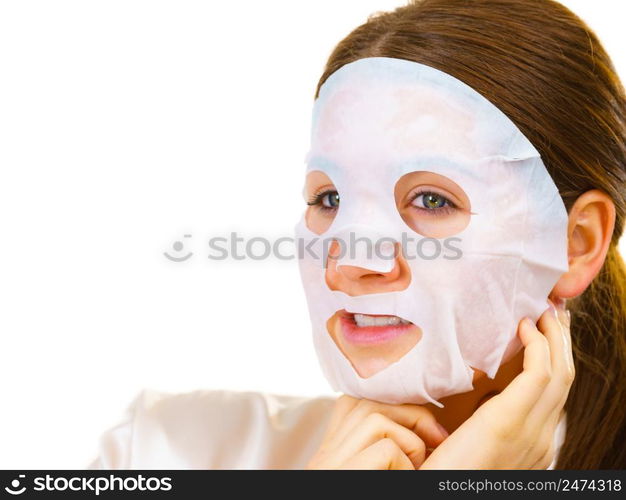 Woman applying sheet mask on her face, on white. Girl taking care of skin complexion. Beauty treatment. Skincare.. Woman applying sheet mask on face