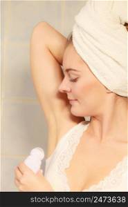 Woman applying stick deodorant in armpit. Girl putting antiperspirant in underarms in bathroom. Daily skin care and hygiene.. Woman applying stick deodorant in armpit