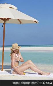 Woman Applying Sun Lotion On Beach Holiday
