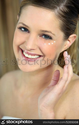 Woman applying under eye cream