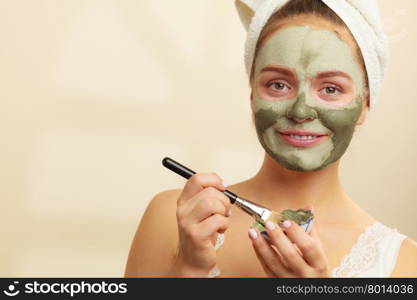 Woman applying with brush clay mud mask to her face . Skin care. Woman applying with brush clay mud mask to her face. Girl taking care of oily complexion. Beauty treatment.