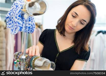 woman arranging fashion accessories in a boutique