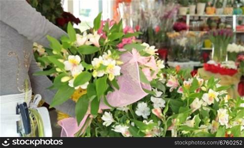 Woman Arranging Flowers In Flower Retail Shop